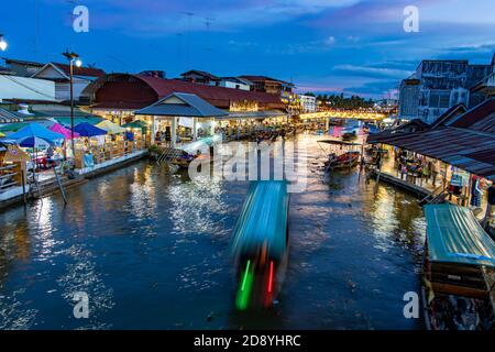 BANGKOK, THAILANDIA, 18 2020 LUGLIO, un tramonto al mercato galleggiante Khlong Lat Mayom con barca offuscata in un canale d'acqua. Foto Stock