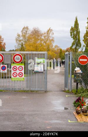 Strasburgo, Francia - 1 novembre 2020: Cimitero in Francia in tutti i Santi giorno durante la seconda ondata del Coronavirus con le persone che estitono il cancello principale - indossare maschere Foto Stock