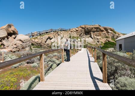 I turisti camminano sulla passerella in legno del Kaiki Trail sull'isola di Granite al largo di Victor Harbour, Australia del Sud Foto Stock