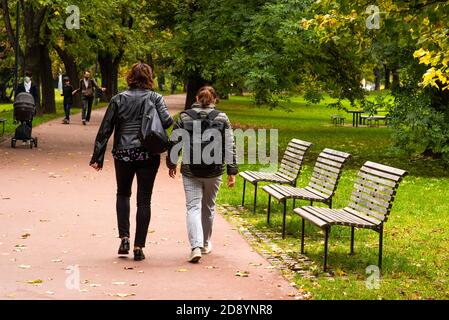 Due donne camminano e parlano al Parco Letna nell'autunno 2020 a Praga 6, durante il periodo di quarantena a causa dello scoppio di COVID-19 come l'inverno sta iniziando Foto Stock