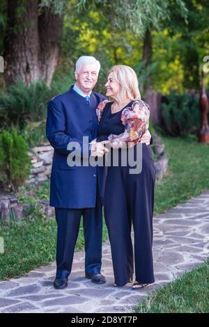 Bella ed elegante coppia anziana che cammina nel parco avendo bello tempo insieme Foto Stock