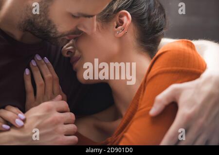 donna depressa appoggiata all'amato uomo abbracciandola e calmandola a casa Foto Stock