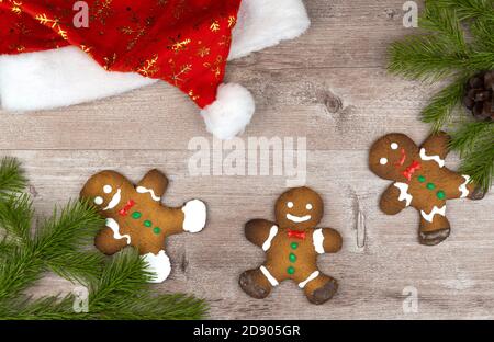 pan di zenzero su una superficie di legno decorata con rami di abete rosso. fuoco selettivo. Foto Stock