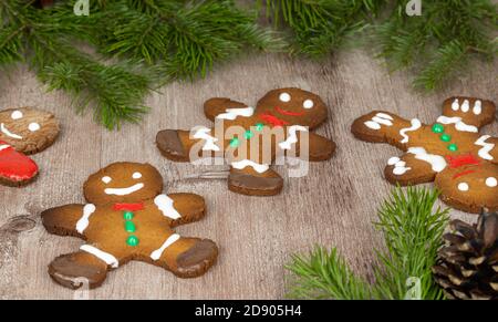 pan di zenzero su una superficie di legno decorata con rami di abete rosso. fuoco selettivo. Foto Stock