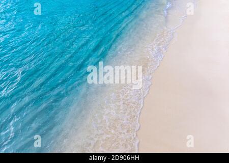 Soffice onda di oceano blu sulla spiaggia di sabbia. Rilassante sfondo della costa dell'oceano. Morbide e dolci onde che spruzzi su sabbia bianca, spiaggia tropicale costa Foto Stock