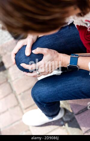 Donna seduta in dolore con ginocchia sulle scale Foto Stock