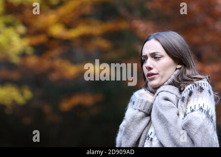 Donna stressata che si fa camminare freddo in autunno in un parco Foto Stock