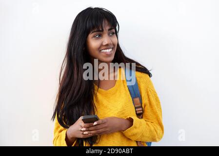 Ritratto di felice giovane donna indiana con telefono cellulare e. sacchetto con fondo bianco isolato Foto Stock