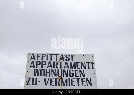 Vecchio segno di affitto di vacanze arrugginito in una destinazione balneare in Italia, in italiano e tedesco Foto Stock