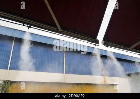 Il sistema di raffreddamento a nebbia d'acqua abbassa la temperatura ambiente del ristorante Foto Stock