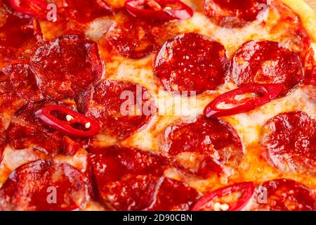 Pizza pepperoni su tavola di legno su sfondo scuro. Primo piano Foto Stock