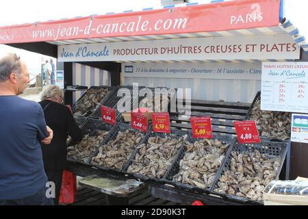 una bancarella di mercato con una varietà di ostriche alla banchina a cancale, bretagna, francia in estate Foto Stock