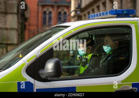 Due agenti di polizia delle West Midlands indossano maschere facciali Pulmino di polizia a Birmingham Foto Stock