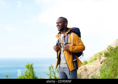 Ritratto dell'uomo afro-americano felice con zaino all'aperto Foto Stock