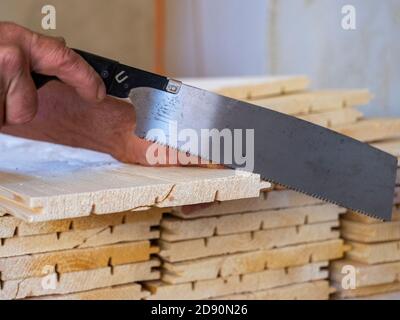 il lavoratore taglia le doghe di legno con la sega Foto Stock