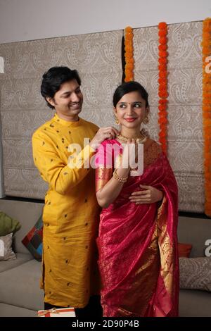 L'uomo indiano legando o presentando la collana d'oro alla sua bella moglie il compleanno, il giorno di San Valentino, l'anniversario o il festival di Diwali. Foto Stock