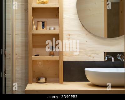 particolare armadio bagno in legno con lavabo ovale e specchio rotondo, vista frontale Foto Stock