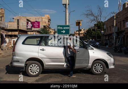 Jaisalmer, Rajasthan / India - Settembre 28 2020 : uomo che entra in una macchina parcheggiata nel mezzo della strada Foto Stock