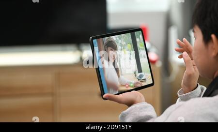 Due ragazze giovani e attraenti comunicano via video con il tablet. Foto Stock