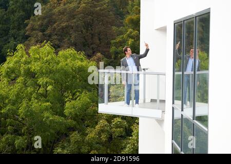 Donna d'affari in piedi sul balcone contro la natura Foto Stock
