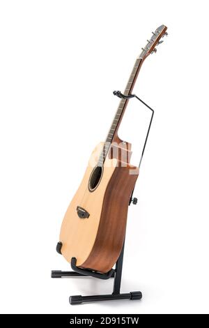 Chitarra acustica con supporto isolato su sfondo bianco Foto Stock