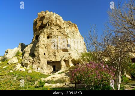L'antica città di Goreme e le sue case e chiese scolpite nella pietra tra le formazioni rocciose dei Camini delle fate in Cappadocia, Turchia Foto Stock