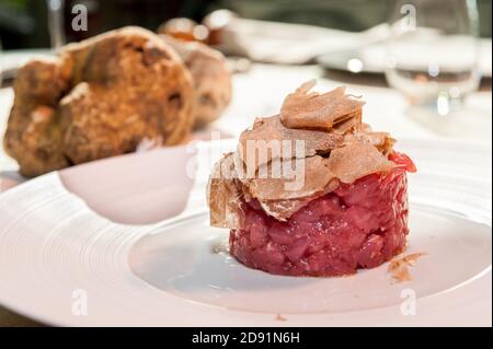 Tartufo bianco di Alba affettato su carne tritata grezza piemontese Bovini di razza Fassona Foto Stock