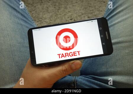 Uomo che tiene uno smartphone con il logo di Target Corporation Foto Stock