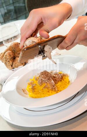 Servire il tartufo bianco di Alba in Italia con un affettare su un piatto di tagliolini-spaghetti all'uovo Foto Stock