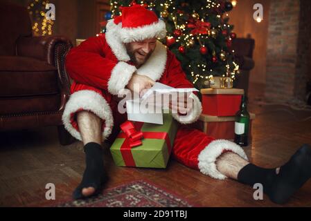 Babbo Babbo natale legge le lettere, l'uomo brutto Foto Stock