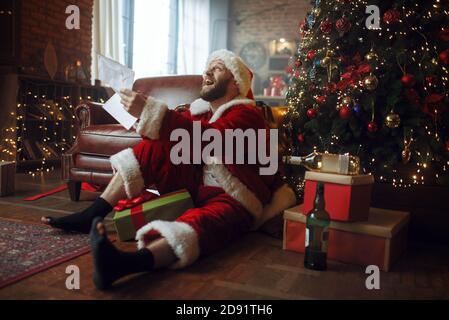 Babbo Babbo natale legge le lettere, l'uomo brutto Foto Stock