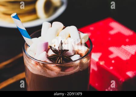 Marshmallows e anice stellato in un bicchiere di cioccolata calda bevanda sullo sfondo di un Capodanno, regalo di Natale. Foto Stock