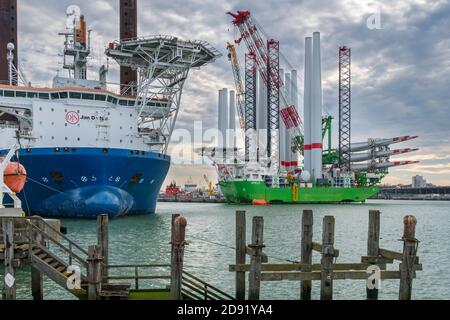 Navi di installazione Apollo e Vole Au Vent ormeggiate presso il terminal di carico pesante REBO nel porto di Ostend, Belgio, che caricano turbine eoliche per l'azienda eolica SeaMade Foto Stock