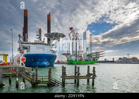 Navi di installazione Apollo e Vole Au Vent ormeggiate presso il terminal di carico pesante REBO nel porto di Ostend, Belgio, che caricano turbine eoliche per l'azienda eolica SeaMade Foto Stock