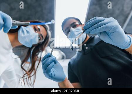 Dentisti maschili e femminili che lavorano insieme in ufficio. Vista in prima persona Foto Stock