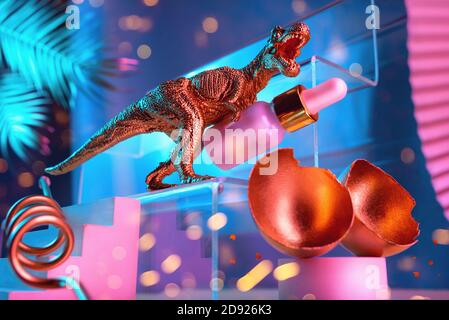 Composizione monumentale con dinosauro, uovo, olio cosmetico per il viso con passerelle, scale, foglie di palma e forme geometriche in colori blu e oro, concetto di bellezza Foto Stock