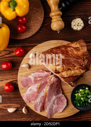 prosciutto affettato su sfondo con verdure e spezie Foto Stock