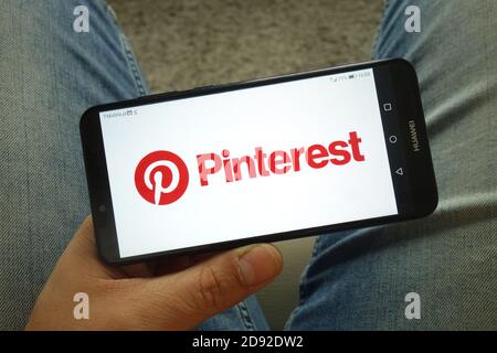 Uomo che tiene uno smartphone con il logo dell'azienda dell'applicazione mobile Pinterest Foto Stock