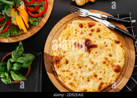 Tortilla di formaggio georgiano, verdure su sfondo nero Foto Stock