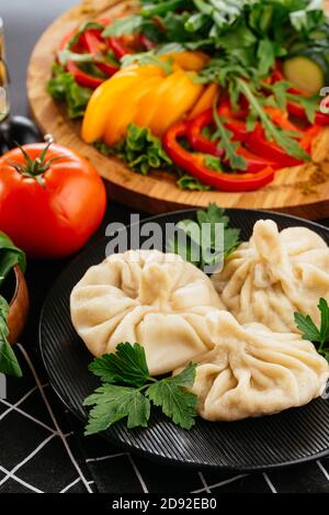 Cucina nazionale georgiana. Khinkali con carne. Khinkali su una tavola di legno primo piano. Foto Stock