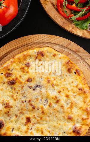 Tortilla di formaggio georgiano, verdure su sfondo nero Foto Stock