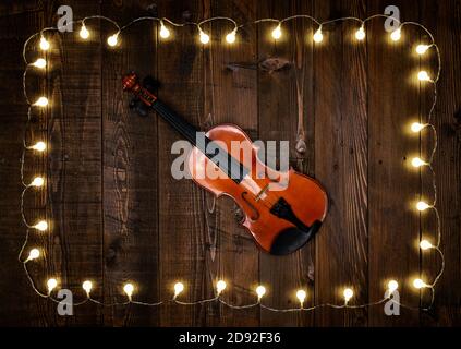 violino su sfondo di legno con lampadine Foto Stock