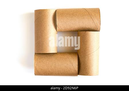 Quadrato formato da quattro tubi di carta di cartone su sfondo bianco. Primo piano dei rotoli di carta igienica vuoti, vista dall'alto Foto Stock