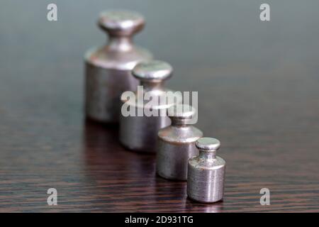 Un set di pesi di ferro graffiati vecchi per una bilancia di farmacia. Foto Stock