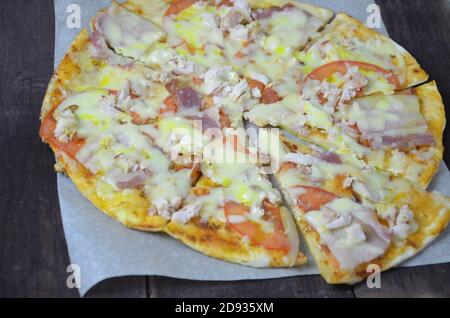 Pizza salame prosciutto di formaggio. Pizza calda fatta in casa Pepperoni pronta a mangiare con ingredienti per cucinare, verdure, aglio, pomodoro Foto Stock