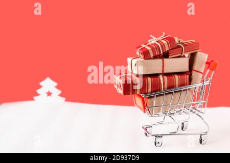 Carrello con regali su sfondo rosso di natale. Foto Stock