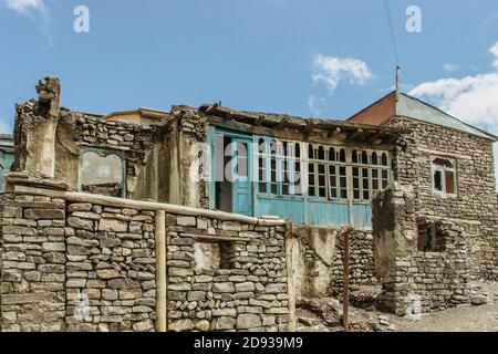 Tipiche case in pietra in un villaggio caucasico. Povero villaggio in Azerbaigian. Case rurali semplici in un antico villaggio di montagna. Tradizionale casa colonica rustica Foto Stock