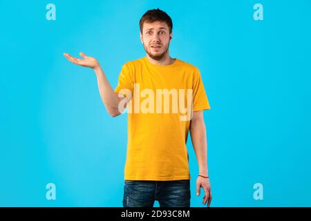 Confuso e perplesso giovane uomo che si è sgombrato in studio Foto Stock