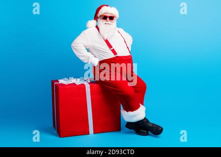 Foto full size di grasso fresco overweight babbo natale con big addome sit x-mas natale magia confezione regalo anno nuovo i sospenditori sono in tuta da sole Foto Stock
