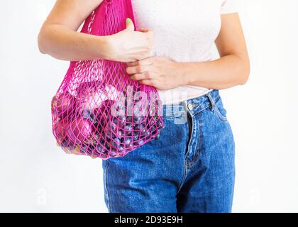 Giovane donna con borsa riutilizzabile in rete con prodotti Foto Stock